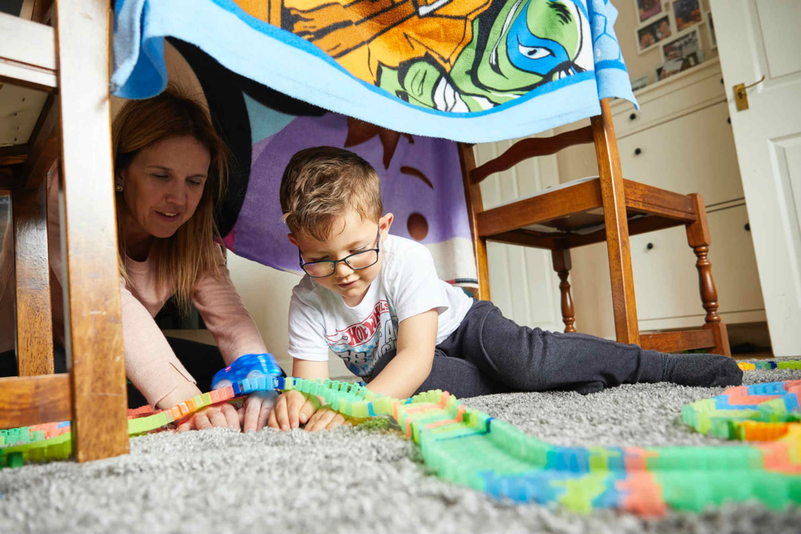 Flavianna and her son Daniel, 4, play inside a homemade tent in their living room, Manchester